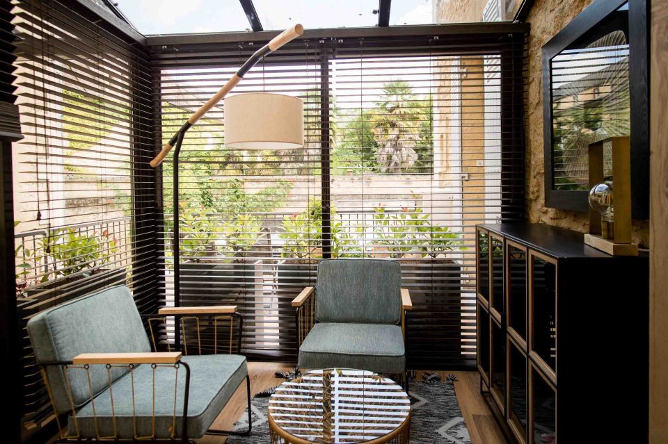 Verrière aménagée en espace lecture avec stores à lamelles bois
