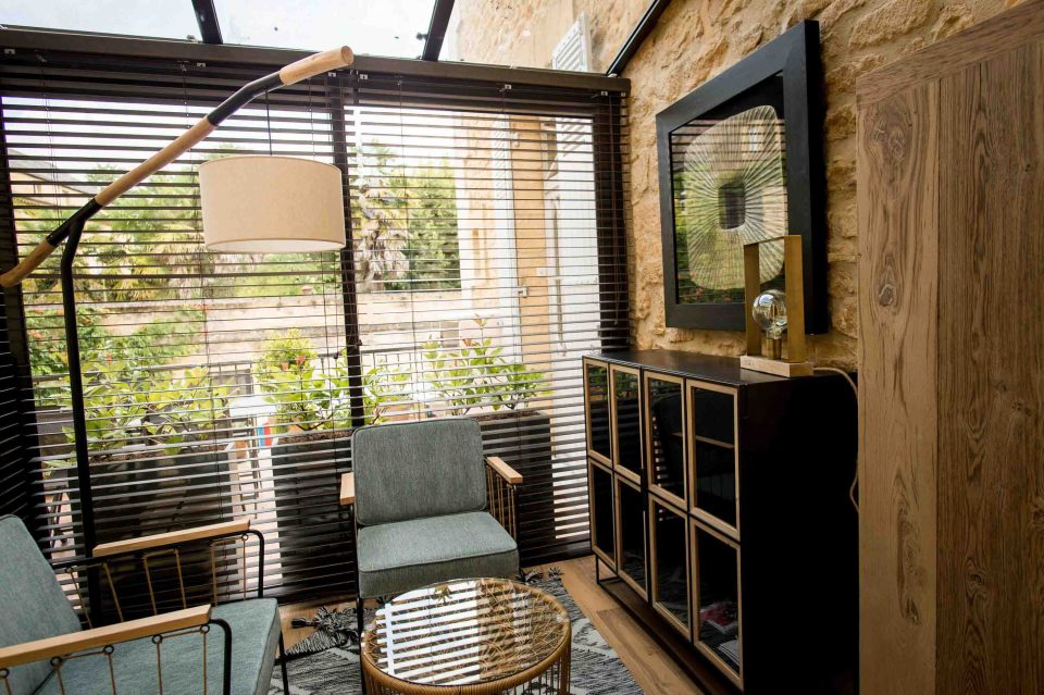 Fauteuils de lecture et meuble-vitrine dans la verrière