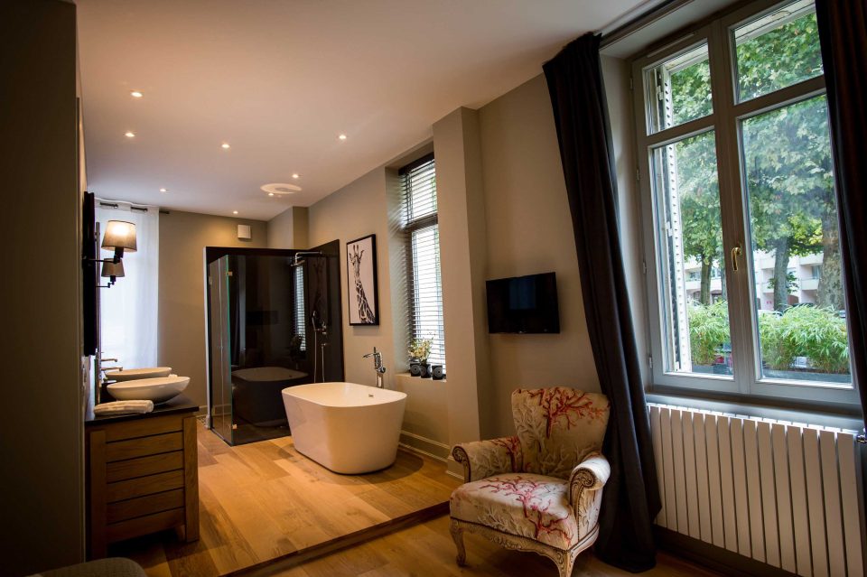 Baignoire hors-sol et parquet en chêne devant les fenêtres