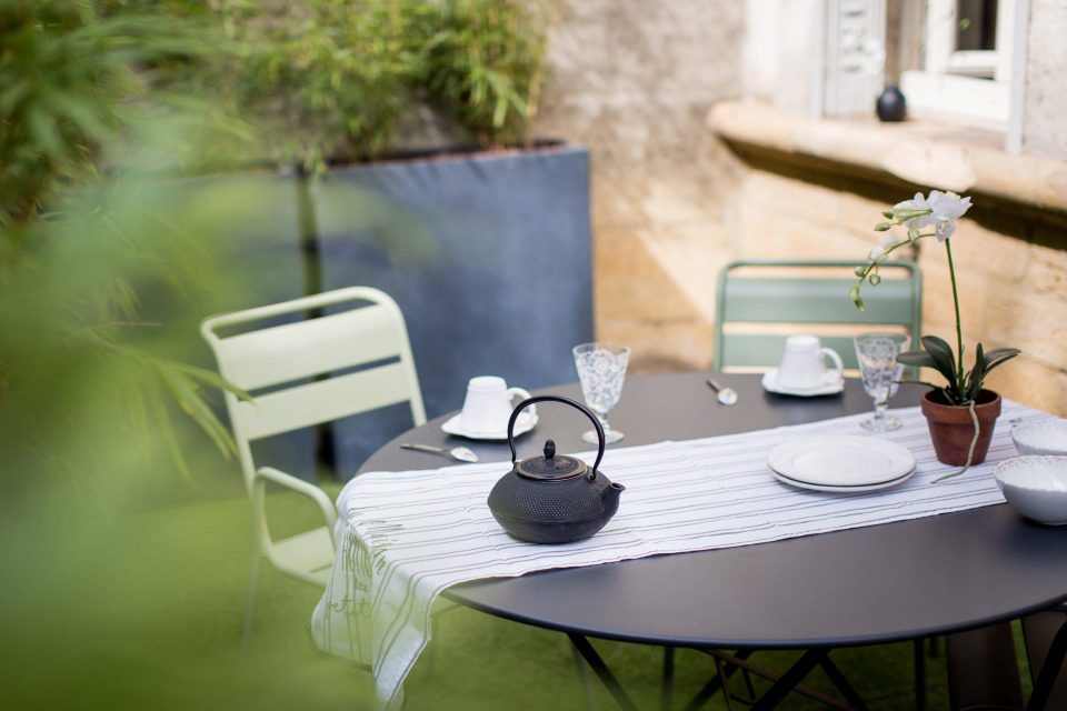 Coin repas de la terrasse avec théière et orchidée