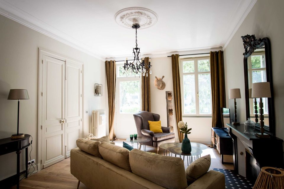 Salon climatisé avec cheminée d'époque et plafonds moulurés